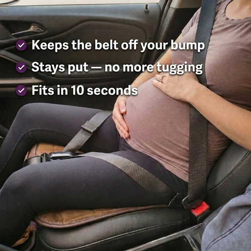 Pregnant driver wearing the MAXSSYPE Bump-Safe Seatbelt Adjuster — belt held low across the thighs, off the bump