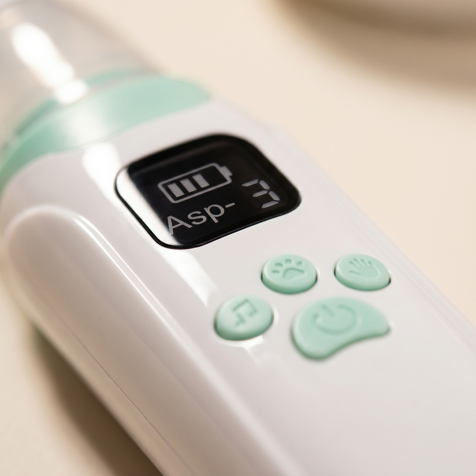 Close-up detail — LED screen displaying battery icon, three mint-green control buttons